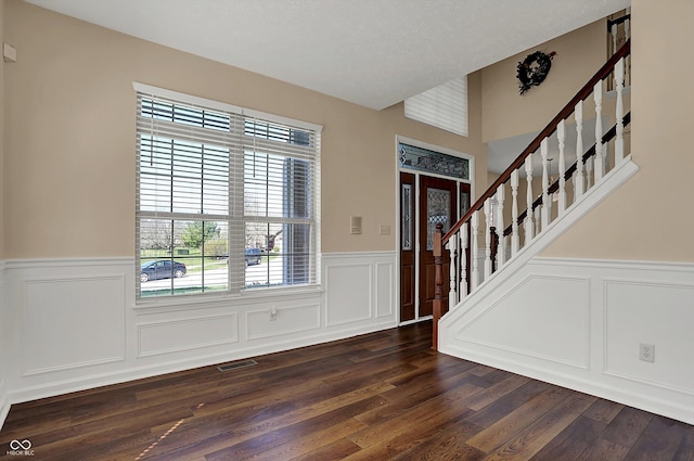 7637 Sand Run Ct, Indianapolis, IN 46259 - foyer with a wainscoted wall, a decorative wall, stairway, and dark wood finished floors