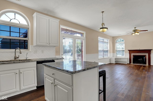 7637 Sand Run Ct, Indianapolis, IN 46259 - kitchen with stainless steel dishwasher, a sink, dark wood-style floors, a kitchen bar, and white cabinetry