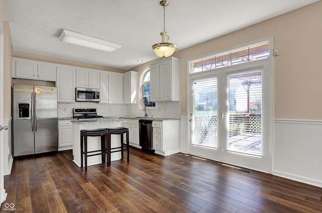 7637 Sand Run Ct, Indianapolis, IN 46259 - kitchen featuring stainless steel appliances, tasteful backsplash, white cabinets, dark wood-type flooring, and pendant lighting