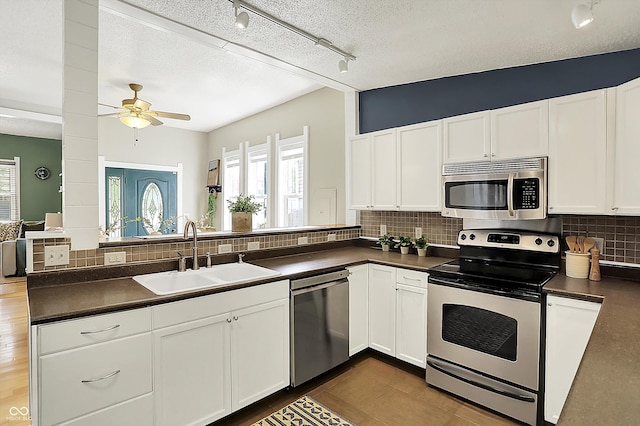 514 Dorman St, Indianapolis, IN 46202 - kitchen featuring appliances with stainless steel finishes, a sink, dark countertops, plenty of natural light, and a textured ceiling
