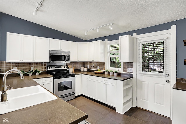 514 Dorman St, Indianapolis, IN 46202 - kitchen with stainless steel appliances, rail lighting, a sink, dark countertops, and a textured ceiling