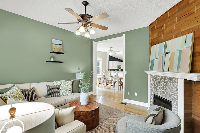 514 Dorman St, Indianapolis, IN 46202 - living area featuring a ceiling fan, wood finished floors, wood walls, a tile fireplace, and baseboards