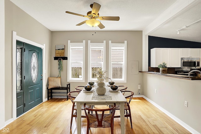 514 Dorman St, Indianapolis, IN 46202 - dining space featuring light wood finished floors, a ceiling fan, a textured ceiling, and baseboards