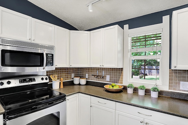 514 Dorman St, Indianapolis, IN 46202 - kitchen featuring stainless steel appliances, dark countertops, white cabinets, a textured ceiling, and backsplash
