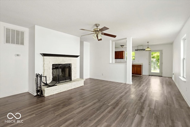 11821 Wapiti Way, Noblesville, IN 46060 - unfurnished living room with dark wood-style floors, a ceiling fan, a fireplace with raised hearth, and baseboards