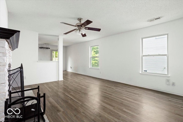 11821 Wapiti Way, Noblesville, IN 46060 - unfurnished living room featuring dark wood finished floors, a textured ceiling, ceiling fan, baseboards, and a fireplace