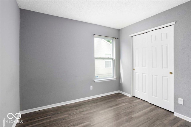 11821 Wapiti Way, Noblesville, IN 46060 - unfurnished bedroom with dark wood-style flooring, a closet, and baseboards