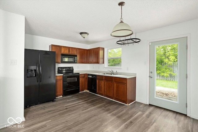 11821 Wapiti Way, Noblesville, IN 46060 - kitchen featuring black appliances, wood finished floors, a sink, light countertops, and a textured ceiling