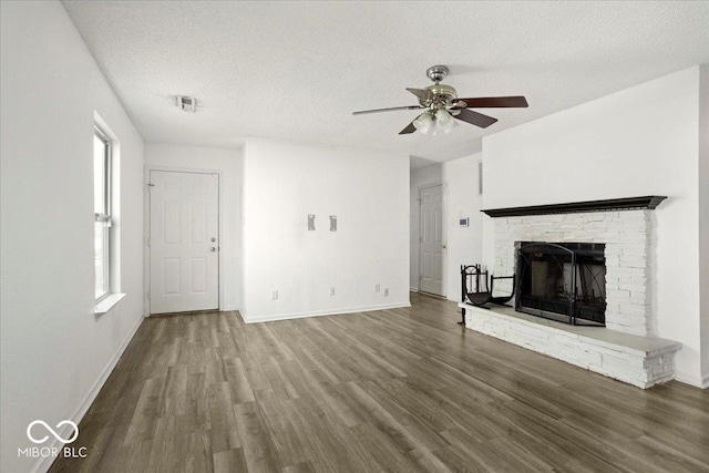 11821 Wapiti Way, Noblesville, IN 46060 - unfurnished living room featuring a ceiling fan, wood finished floors, plenty of natural light, a fireplace with raised hearth, and a textured ceiling