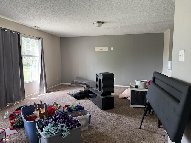 carpeted living area with a textured ceiling and baseboards