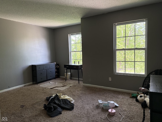 unfurnished bedroom featuring a textured ceiling, carpet flooring, and baseboards
