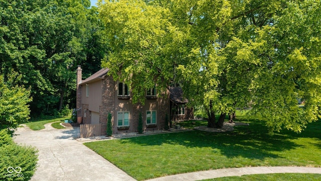 3479 Sugar Loaf Ct, Carmel, IN 46033 - view of property hidden behind natural elements featuring concrete driveway, a chimney, a front lawn, and brick siding