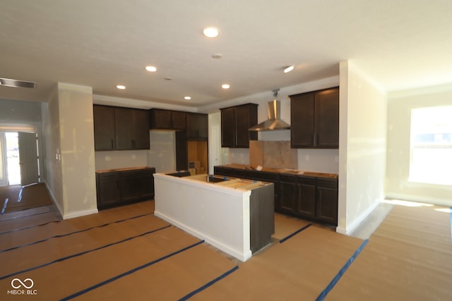 5517 Sienna Ct, Brownsburg, IN 46112 - kitchen featuring wall chimney range hood, dark brown cabinetry, recessed lighting, baseboards, and a center island