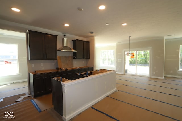 5517 Sienna Ct, Brownsburg, IN 46112 - kitchen featuring wall chimney range hood, recessed lighting, dark brown cabinetry, baseboards, and a center island