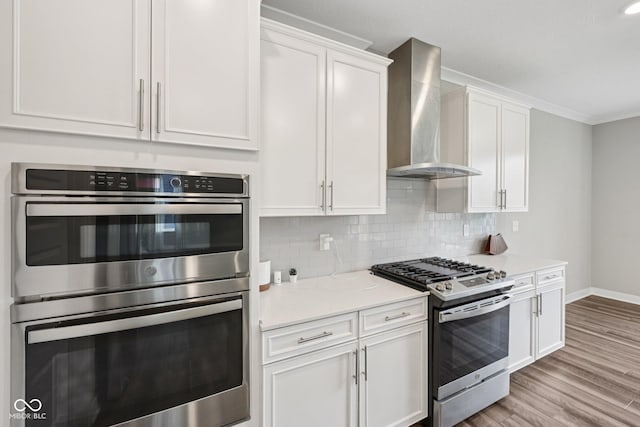 15418 Tattersalls Ln, Fishers, IN 46040 - kitchen with stainless steel appliances, wall chimney range hood, white cabinets, decorative backsplash, and crown molding