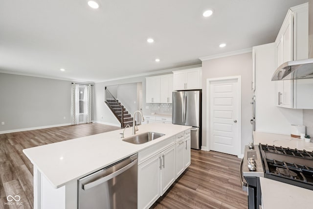 15418 Tattersalls Ln, Fishers, IN 46040 - kitchen featuring appliances with stainless steel finishes, ornamental molding, wall chimney exhaust hood, light wood-style flooring, and light countertops
