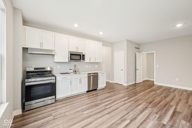 15418 Tattersalls Ln, Fishers, IN 46040 - kitchen with appliances with stainless steel finishes, under cabinet range hood, light wood-type flooring, white cabinets, and recessed lighting
