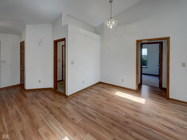 4825 May Ridge Ln, Indianapolis, IN 46254 - unfurnished room featuring a chandelier, light wood-type flooring, baseboards, and high vaulted ceiling