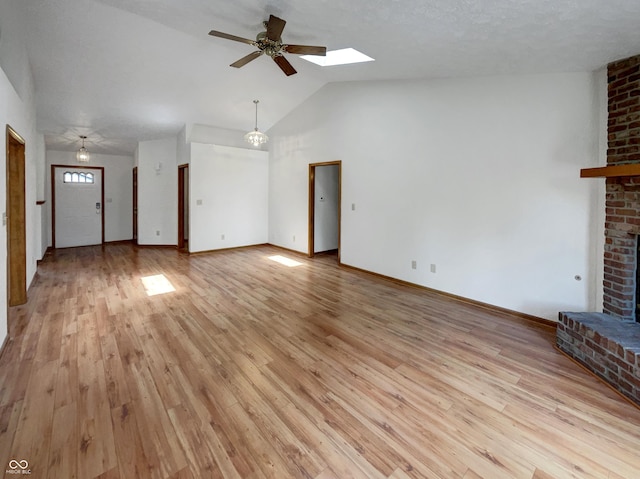 4825 May Ridge Ln, Indianapolis, IN 46254 - unfurnished living room with a brick fireplace, a ceiling fan, light wood-type flooring, a skylight, and baseboards