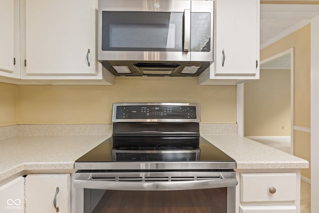 8934 Pinyon Ct, Indianapolis, IN 46260 - kitchen featuring appliances with stainless steel finishes, white cabinets, light countertops, and ornamental molding