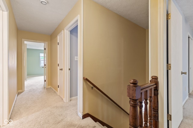 8934 Pinyon Ct, Indianapolis, IN 46260 - hall featuring an upstairs landing, light colored carpet, a textured ceiling, and baseboards