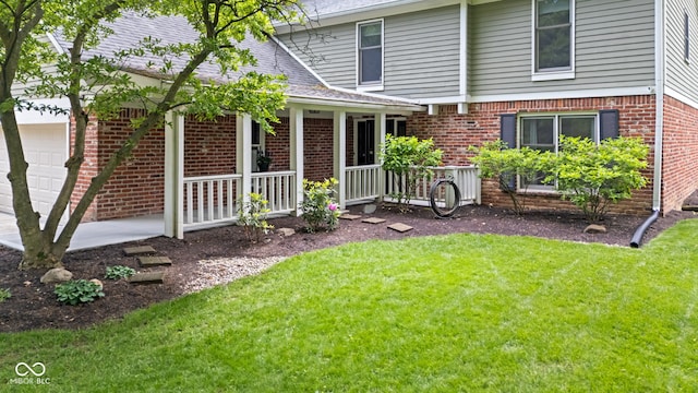 8934 Pinyon Ct, Indianapolis, IN 46260 - view of front facade featuring covered porch, brick siding, a garage, and a front yard