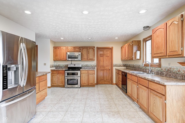 7333 State Road 42, Martinsville, IN 46151 - kitchen with appliances with stainless steel finishes, a sink, recessed lighting, a textured ceiling, and brown cabinets
