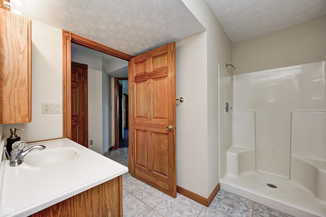 7333 State Road 42, Martinsville, IN 46151 - bathroom featuring a textured ceiling, a shower, baseboards, and vanity