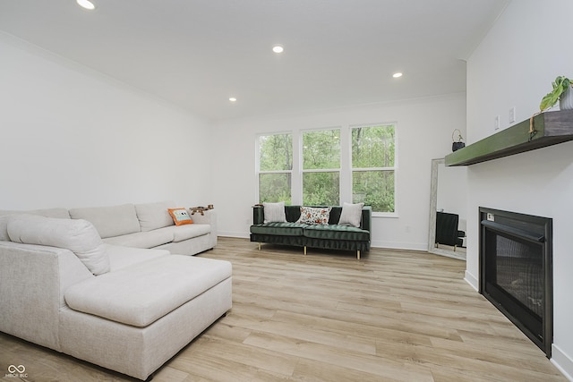 1510 Stonehaven Dr, Westfield, IN 46074 - living room with crown molding, baseboards, recessed lighting, light wood-style floors, and a glass covered fireplace