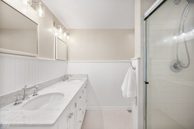 6020 Gladden Dr, Indianapolis, IN 46220 - full bathroom featuring double vanity, a wainscoted wall, tiled shower, tile patterned floors, and baseboards