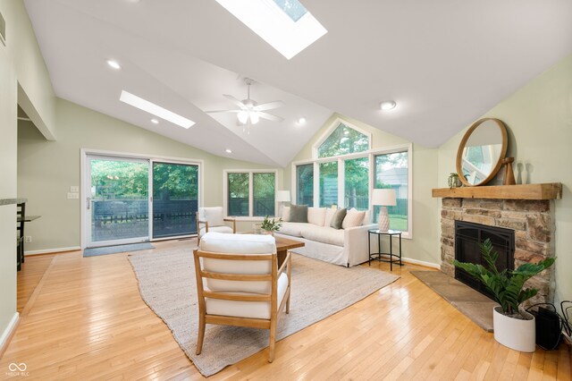 6020 Gladden Dr, Indianapolis, IN 46220 - living room with a skylight, a stone fireplace, light wood finished floors, vaulted ceiling, and plenty of natural light