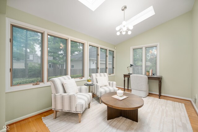 6020 Gladden Dr, Indianapolis, IN 46220 - living area featuring a skylight, a chandelier, lofted ceiling, wood finished floors, and baseboards