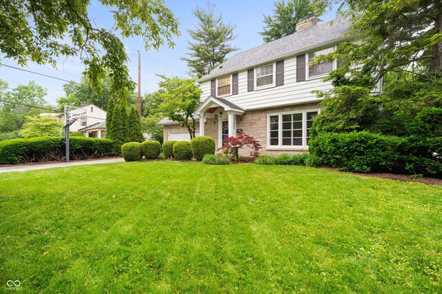 6020 Gladden Dr, Indianapolis, IN 46220 - colonial-style house featuring a front yard, stone siding, and a chimney