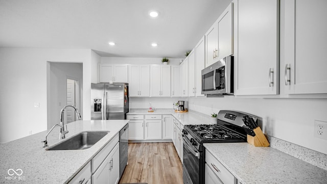 7226 Sayers Rd, Indianapolis, IN 46259 - kitchen featuring appliances with stainless steel finishes, a sink, recessed lighting, white cabinets, and light wood finished floors