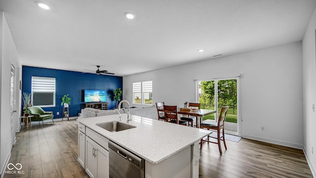 7226 Sayers Rd, Indianapolis, IN 46259 - kitchen with stainless steel dishwasher, a sink, a ceiling fan, wood finished floors, and a kitchen island with sink