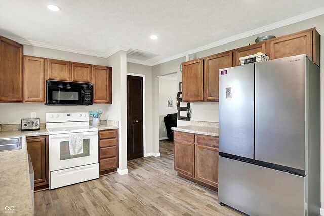 200 Forum Dr, Whiteland, IN 46184 - kitchen featuring freestanding refrigerator, white range with electric stovetop, black microwave, light wood-style floors, and brown cabinetry
