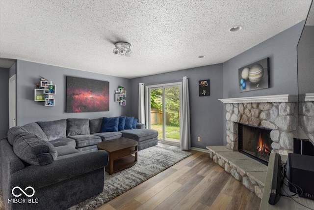 8446 S Paddleboat Ln, Pendleton, IN 46064 - living room with wood finished floors, a textured ceiling, a fireplace, and baseboards