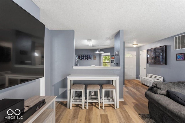 8446 S Paddleboat Ln, Pendleton, IN 46064 - kitchen featuring wood finished floors, baseboards, and a textured ceiling
