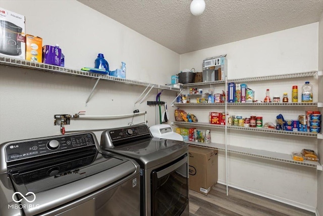 8446 S Paddleboat Ln, Pendleton, IN 46064 - laundry room featuring washing machine and dryer, wood finished floors, and a textured ceiling