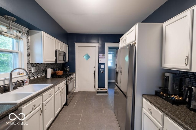 3934 N Kenwood Ave, Indianapolis, IN 46208 - kitchen with appliances with stainless steel finishes, a sink, dark countertops, and plenty of natural light