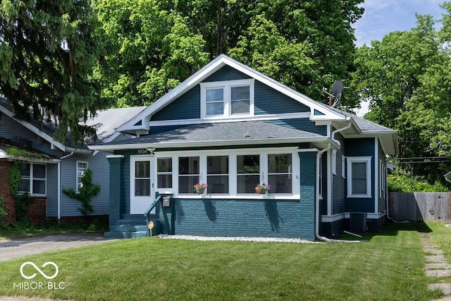 3934 N Kenwood Ave, Indianapolis, IN 46208 - bungalow with roof with shingles, brick siding, and central air condition unit