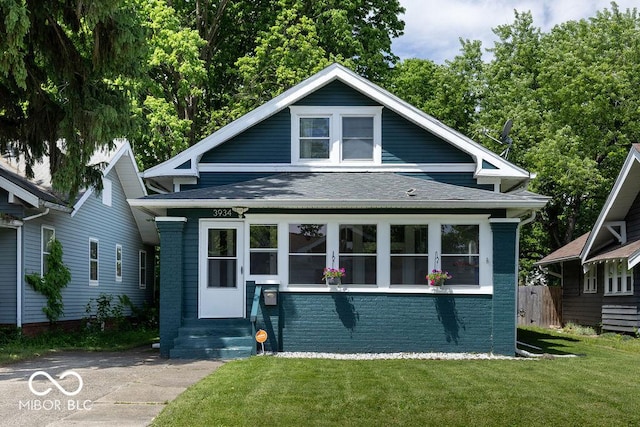 3934 N Kenwood Ave, Indianapolis, IN 46208 - bungalow featuring brick siding, roof with shingles, and a front yard