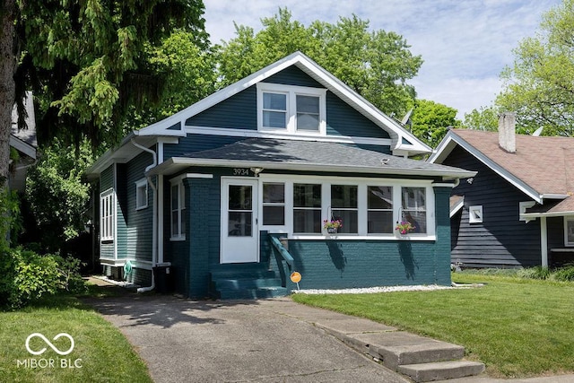 3934 N Kenwood Ave, Indianapolis, IN 46208 - bungalow-style home featuring entry steps, brick siding, a front lawn, and a shingled roof