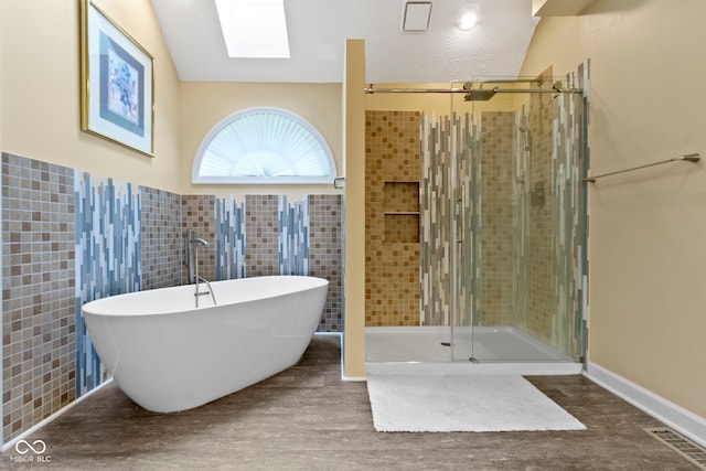 8723 Bergeson Dr, Indianapolis, IN 46278 - bathroom featuring a freestanding tub, a shower stall, wood finished floors, and tile walls