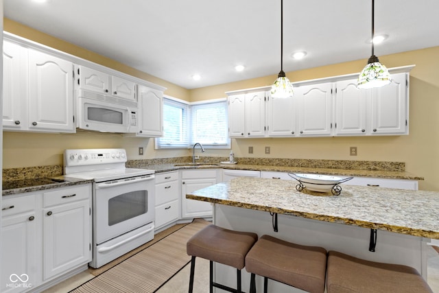 8723 Bergeson Dr, Indianapolis, IN 46278 - kitchen featuring white appliances, a breakfast bar, white cabinetry, a sink, and light stone countertops