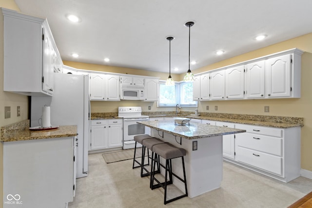 8723 Bergeson Dr, Indianapolis, IN 46278 - kitchen with white appliances, white cabinets, a breakfast bar, and recessed lighting