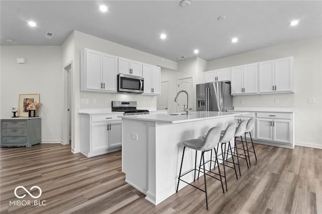 14350 Ludwell Ct, Fishers, IN 46037 - kitchen featuring stainless steel appliances, a sink, light wood finished floors, white cabinets, and recessed lighting
