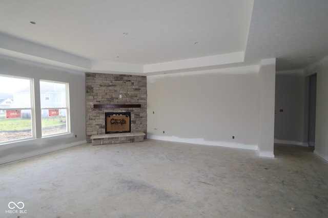 4290 Ironclad Dr, Bargersville, IN 46106 - unfurnished living room featuring unfinished concrete flooring, a fireplace, a raised ceiling, and baseboards