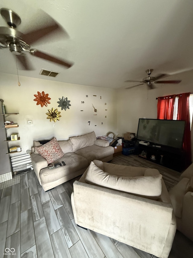 living area featuring ceiling fan and wood tiled floors