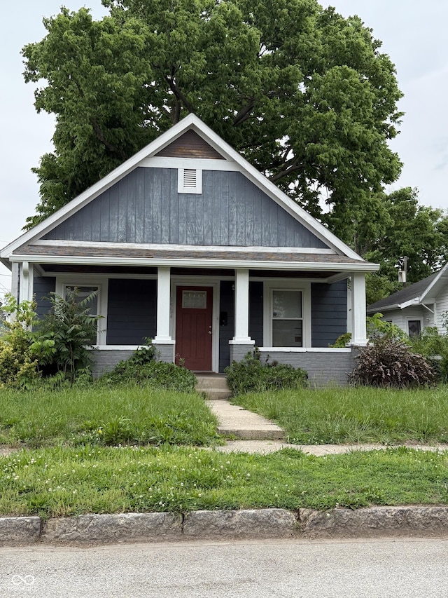 bungalow with a porch and brick siding